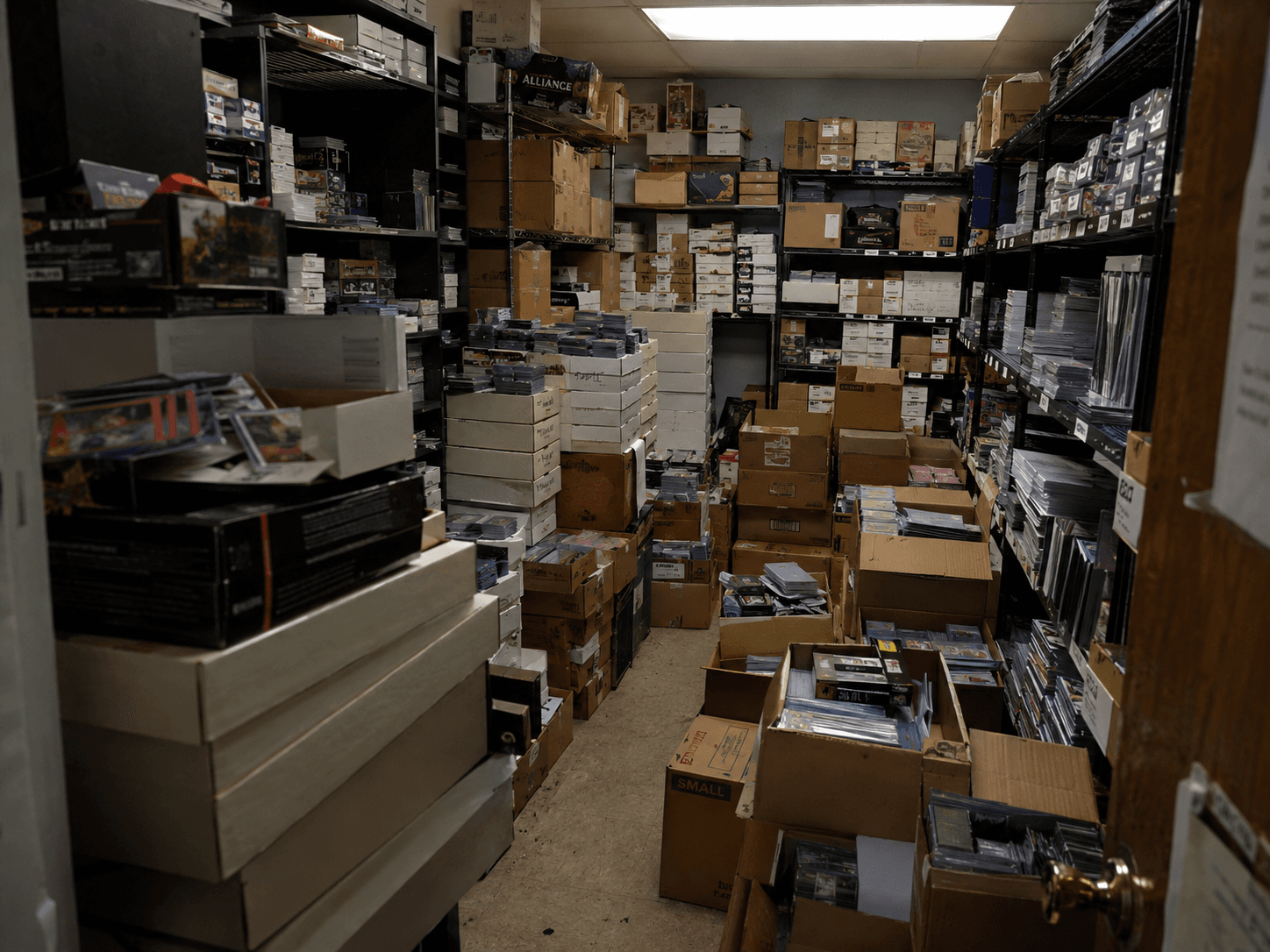 Back room of a card shop stacked with boxes of unsorted trading cards
